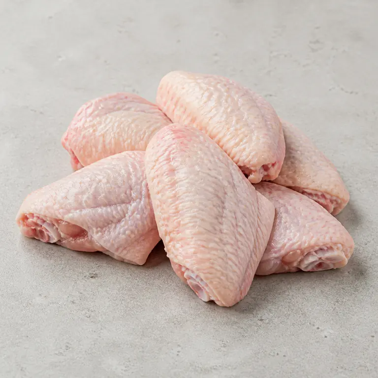 Alas de pollo (crudo) sobre una superficie neutra